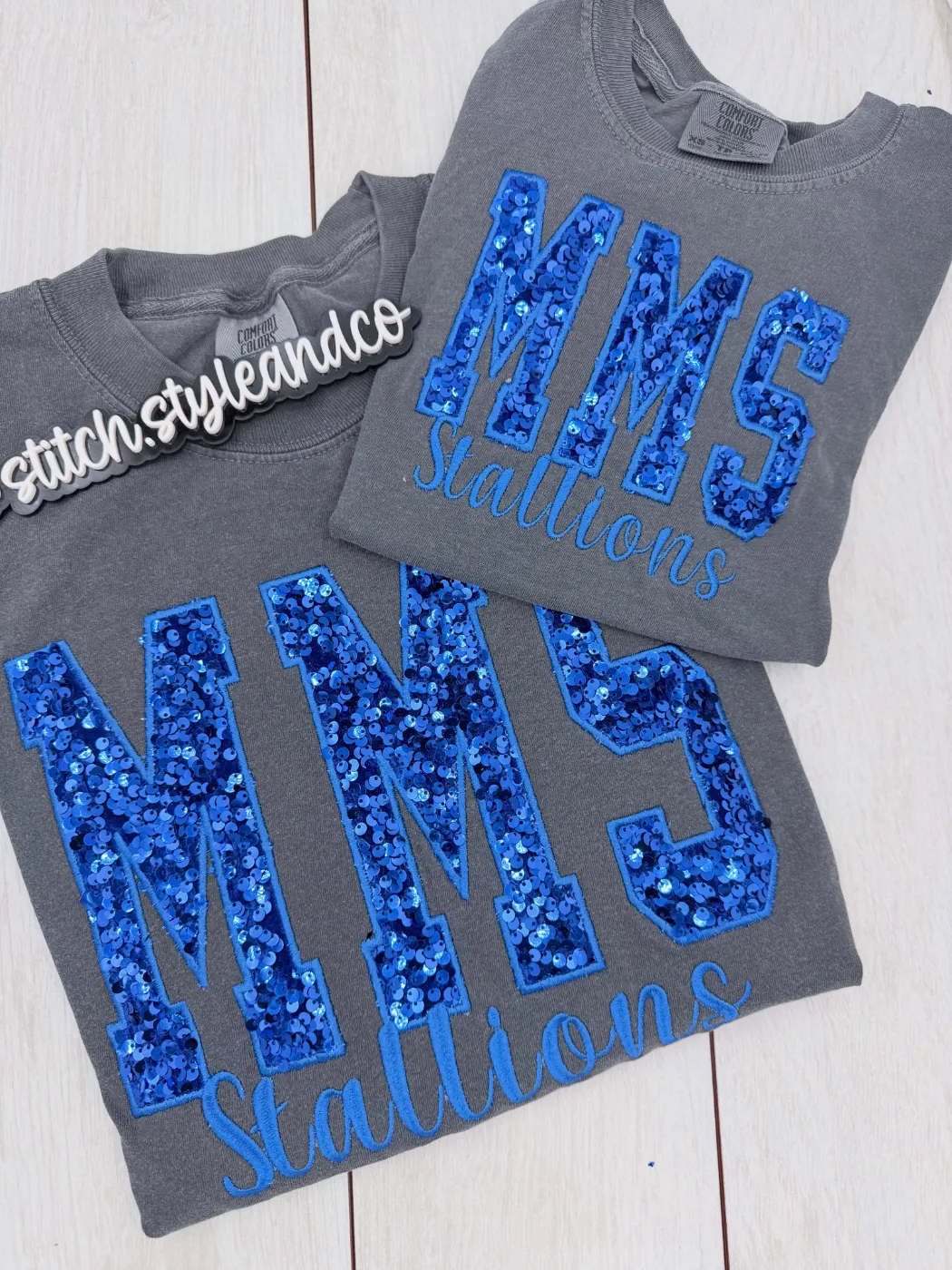 Two grey shirts with royal blue sequin MMS and Stallions in script