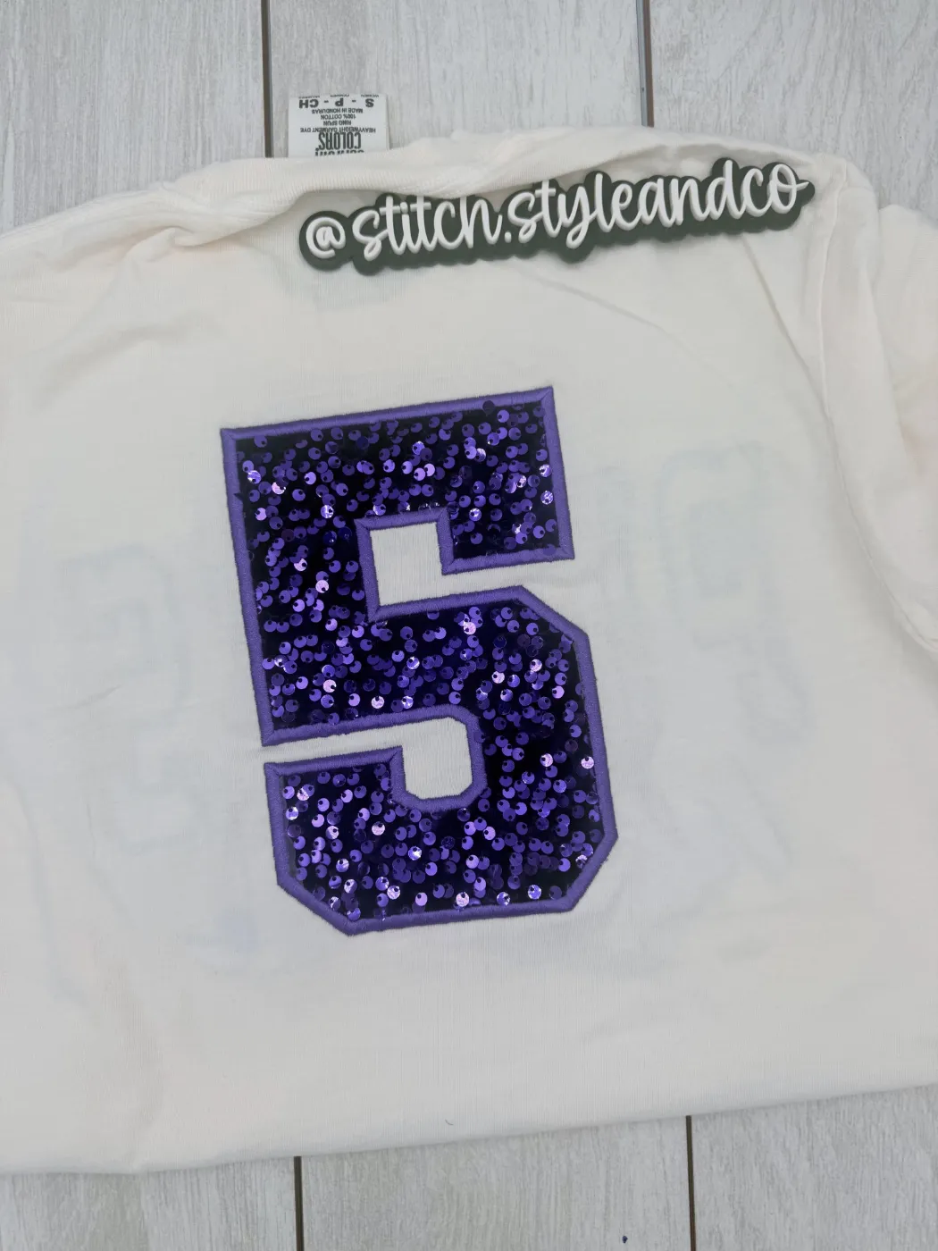 Cream shirt with a large purple sequin number 5